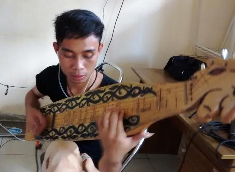 Pemuda Dayak main alat musik sape Pemuda Dayak main alat musik sape